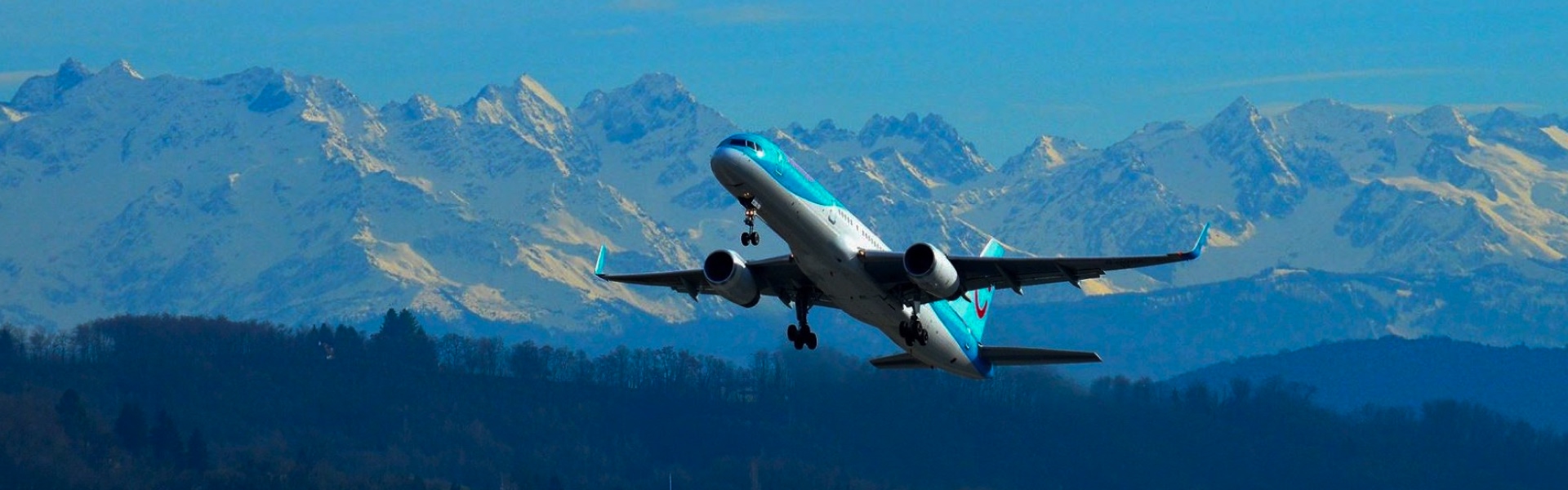 Aeroplane taking off in front of the Alps
